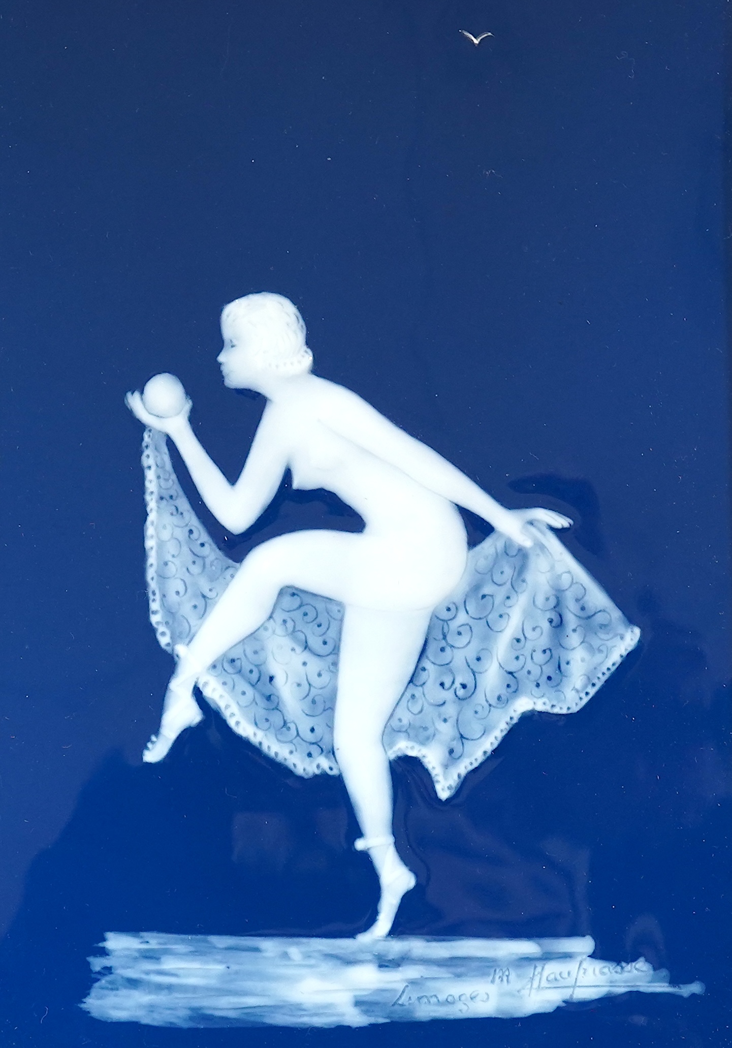 A 20th century framed Limoges blue and white pate-sur-pate plaque, of a female dancer with a ball, signed Marcel, plaque 12cm x 17.5cm. Condition -good